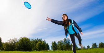 woman throws frisbee